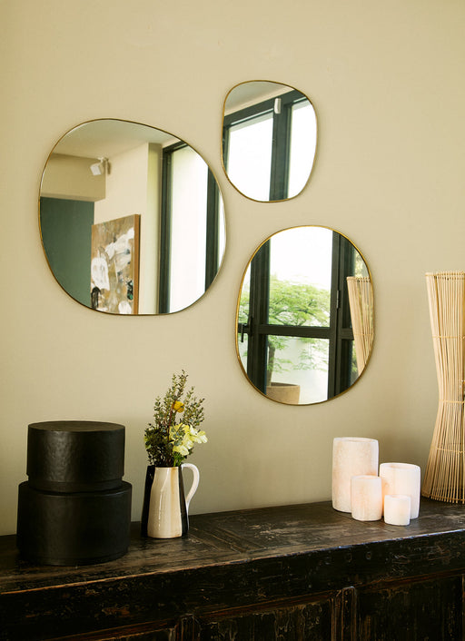 composition des trois miroirs muraux Ame en laiton doré dans un salon élégant