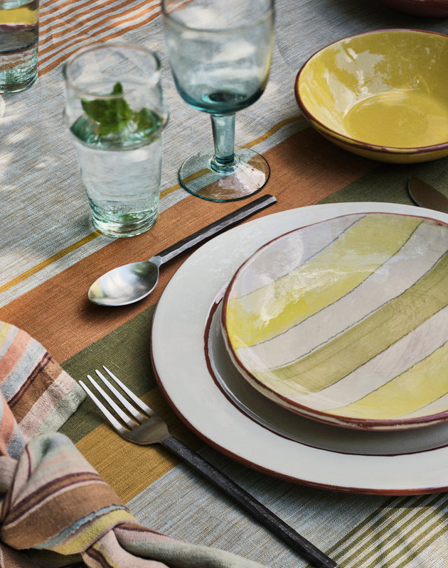 Table d'été dressée avec le linge de table Soleo et l'assiette en terre cuite Amalfi