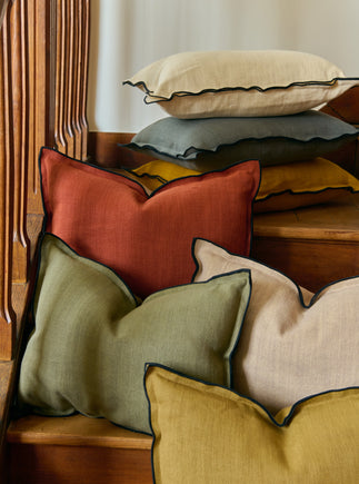 Ensemble de sept coussins en lin Gareth colorés avec un bourdon noir