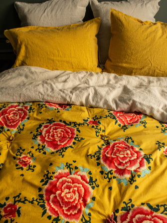 Linge de lit jaune curcuma avec des fleurs rouges