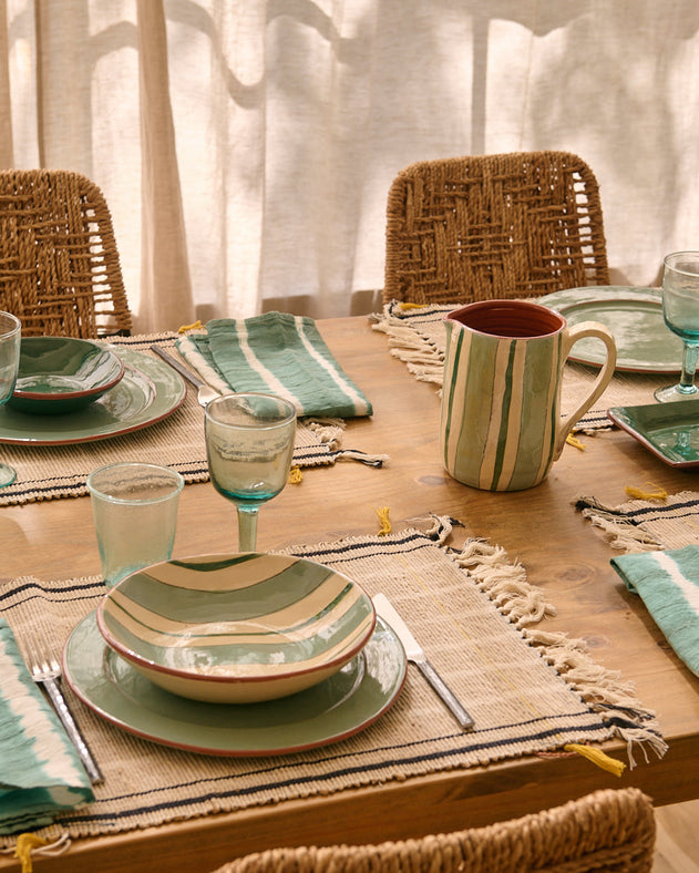 Table d'été dressée avec la vaisselle Amalfi à rayures bleues et blanches en terre cuite
