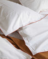 Literie : drap en coton blanc avec les coutures rouges