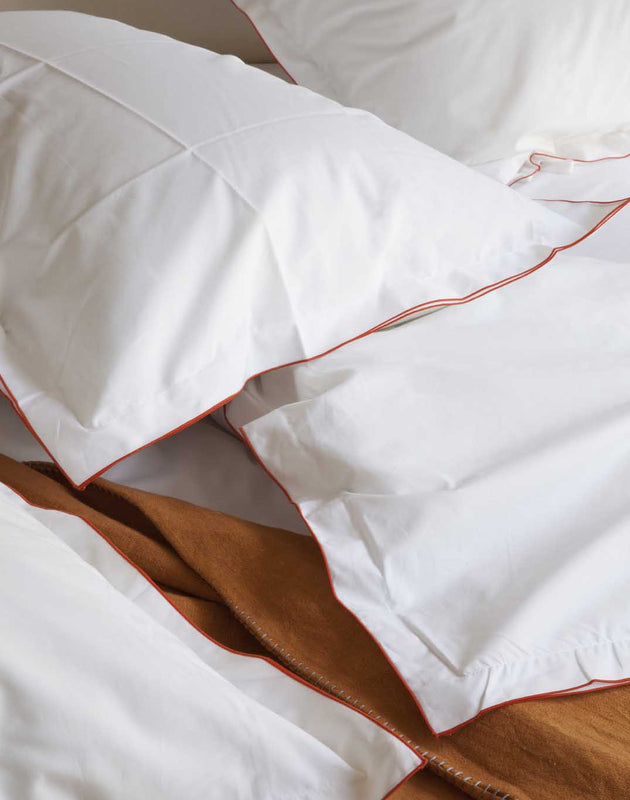 Literie : drap en coton blanc avec les coutures rouges