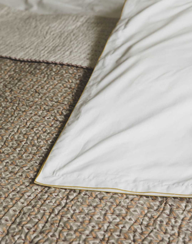 Literie : linge de lit blanc en coton avec un liseré jaune