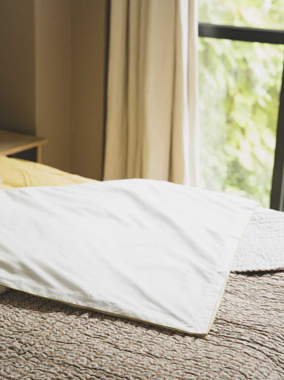 literie : drap blanc avec un liseré jaune