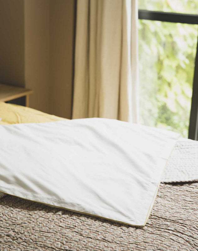 literie : drap blanc avec un liseré jaune