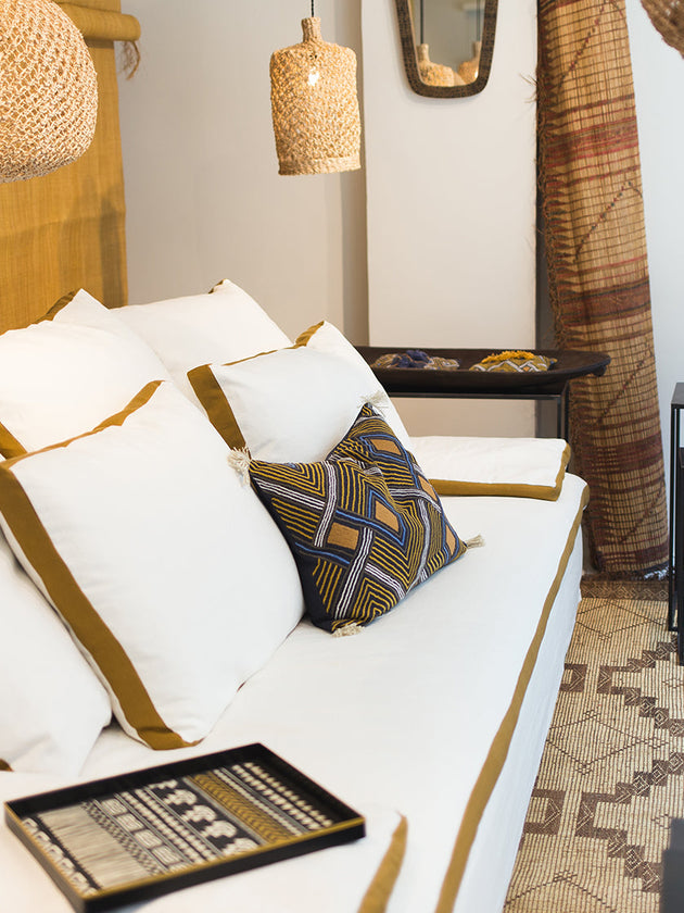 Détail du grand divan Calife blanc avec ses plate-bandes colorées et ses coussins