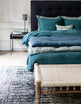 Literie bleue avec courtepointe en bout de lit