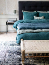 Literie bleue avec courtepointe en bout de lit