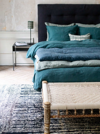 Literie bleue avec courtepointe en bout de lit