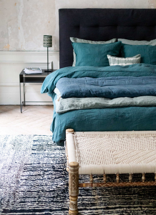 Literie bleue avec courtepointe en bout de lit