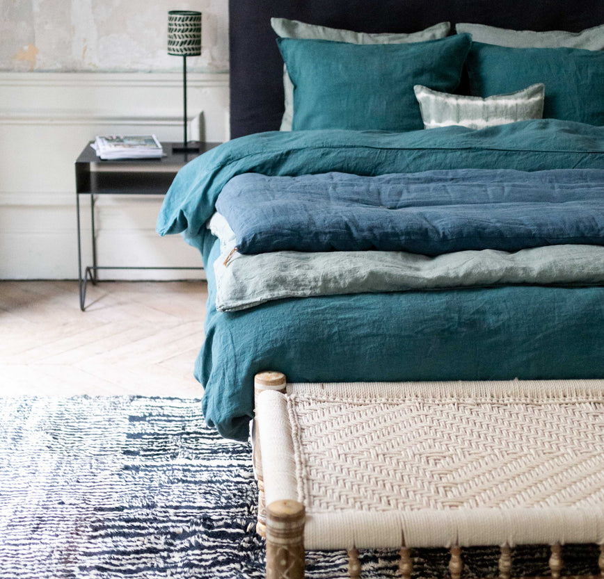 Literie bleue avec courtepointe en bout de lit