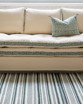 Canapé blanc avec des imprimés végétaux verts autour des coussins