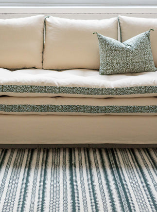 Canapé blanc avec des imprimés végétaux verts autour des coussins