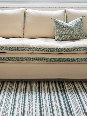 Canapé blanc avec des imprimés végétaux verts autour des coussins