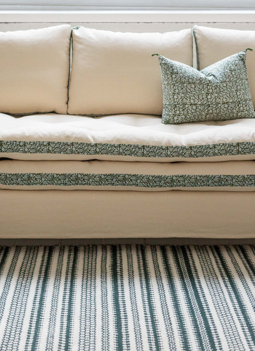 Canapé blanc avec des imprimés végétaux verts autour des coussins