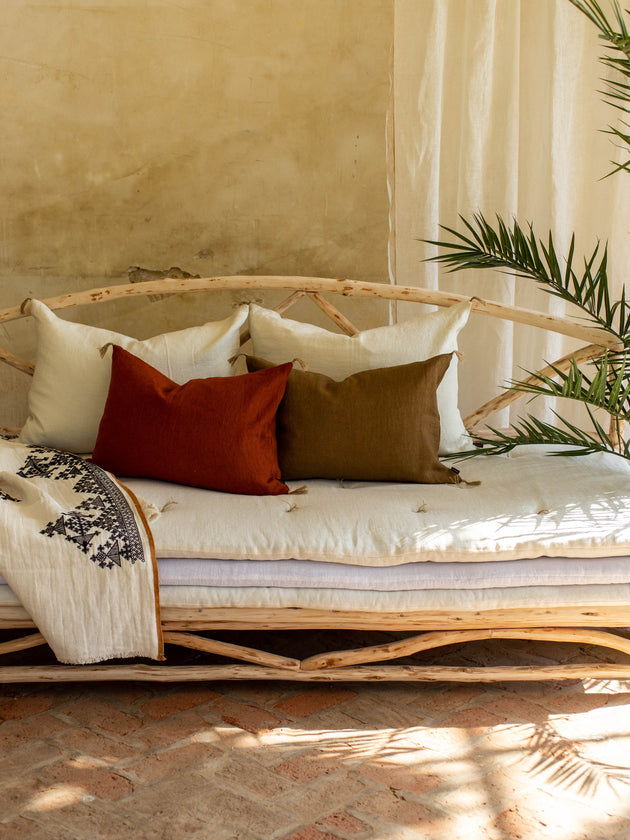 Ensemble de quatre coussins Luni en lin disposés sur un divan.