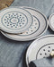 Assiettes originales blanches avec des pois noirs
