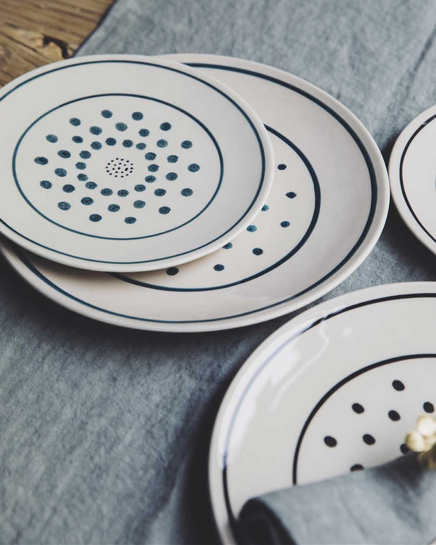 Assiettes originales blanches avec des pois noirs
