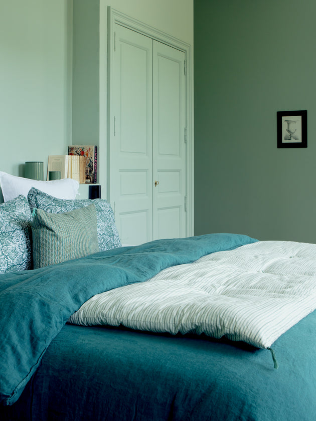 Chambre bleue avec du linge de lit Selena en lin lavé et une courtepointe en bout de lit