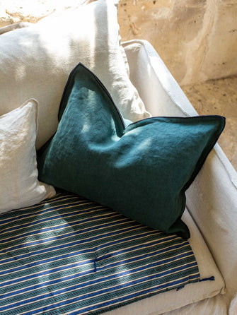 Housse de coussin Maya colvert sur un canapé blanc