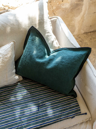 Housse de coussin Maya colvert sur un canapé blanc
