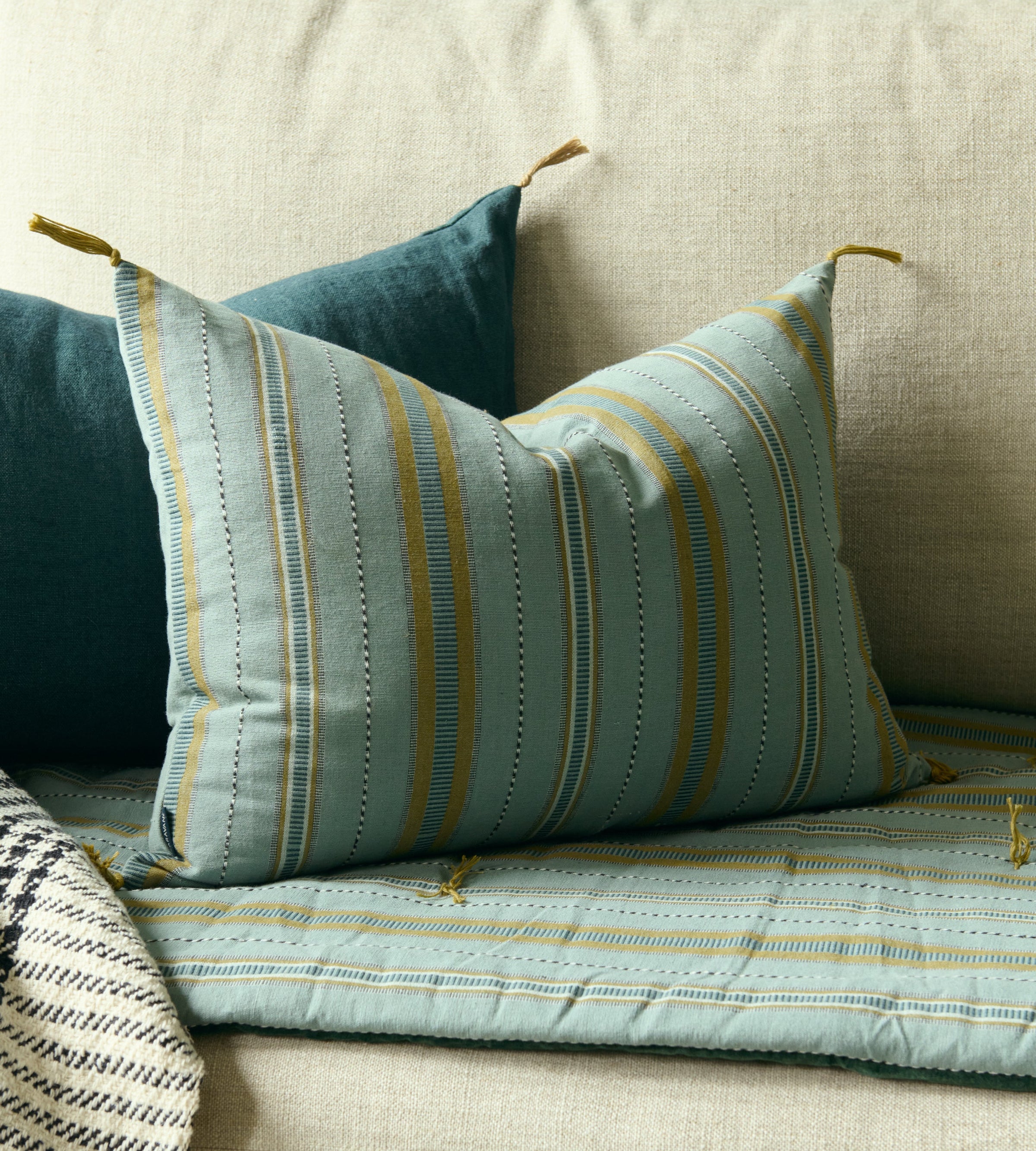 Housse de coussin Noely à rayures avec les pompons signature Caravane aux coins
