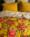 Linge de lit jaune avec des fleurs rouges
