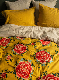 Linge de lit jaune avec des fleurs rouges