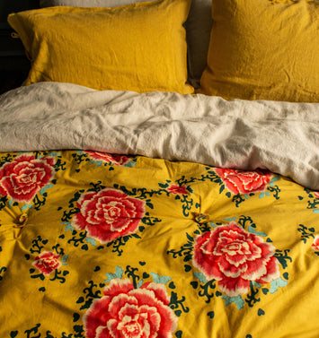 Linge de lit jaune avec des fleurs rouges