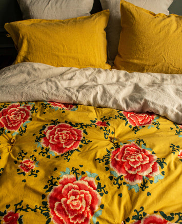 Linge de lit jaune avec des fleurs rouges