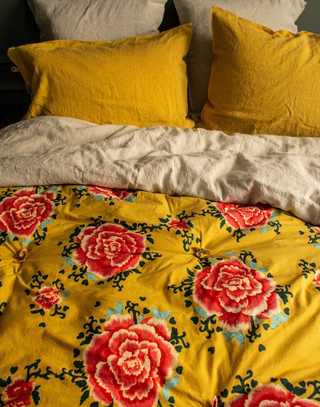 Linge de lit jaune avec des fleurs rouges