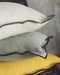 Housse de coussin en lin avec un bord noir en blanc, sauge et moutarde