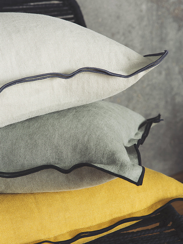 Housse de coussin en lin avec un bord noir en blanc, sauge et moutarde