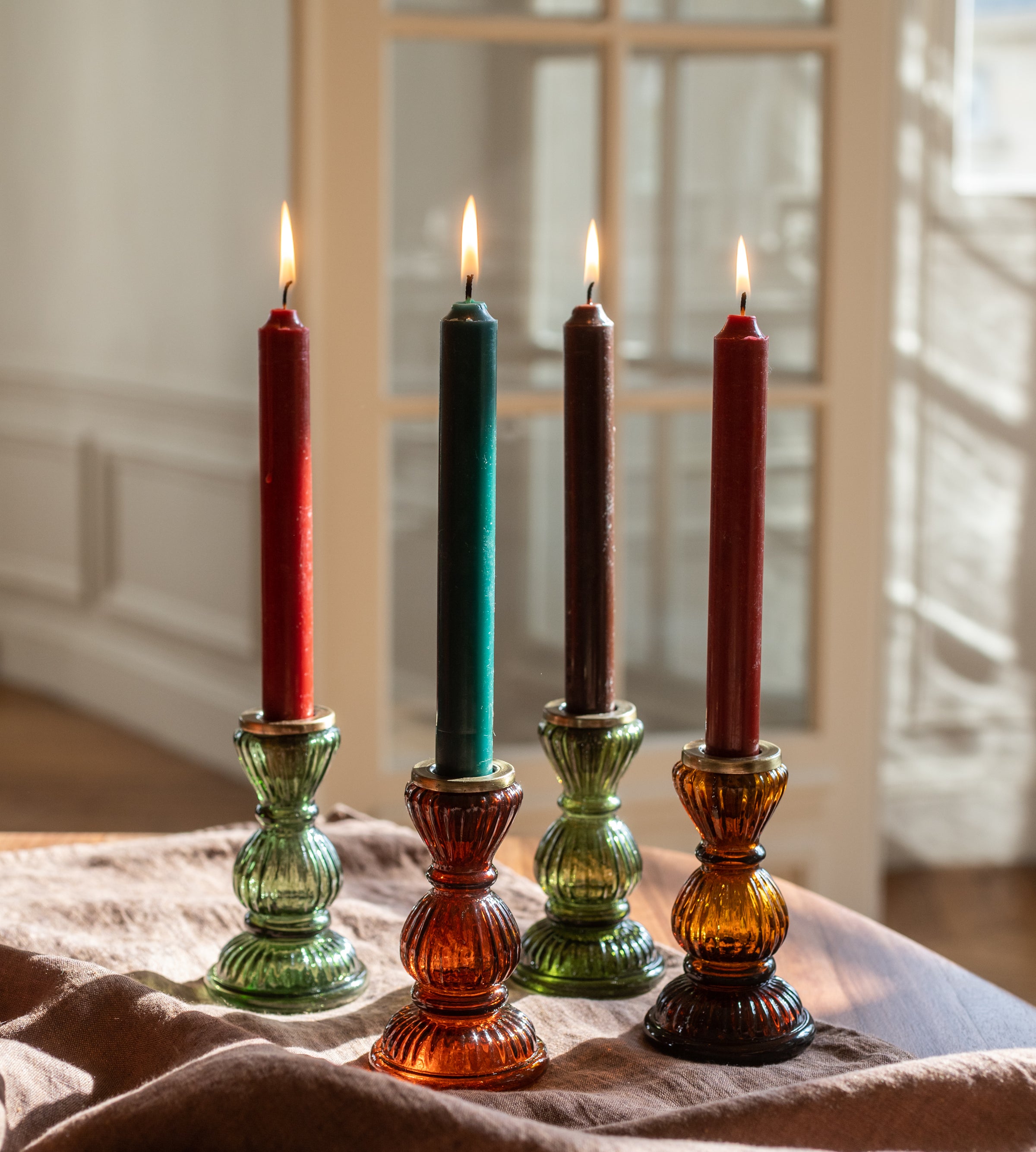 Quatre chandelles en cire et leurs bougeoirs en verre recyclé