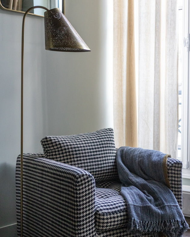 Lampadaire Ella bronze en acier à côté du fauteuil Stella