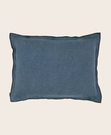 Housse de coussin bleu avec un bord noir en lin