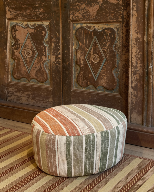 Pouf à rayures colorées sur un tapis.