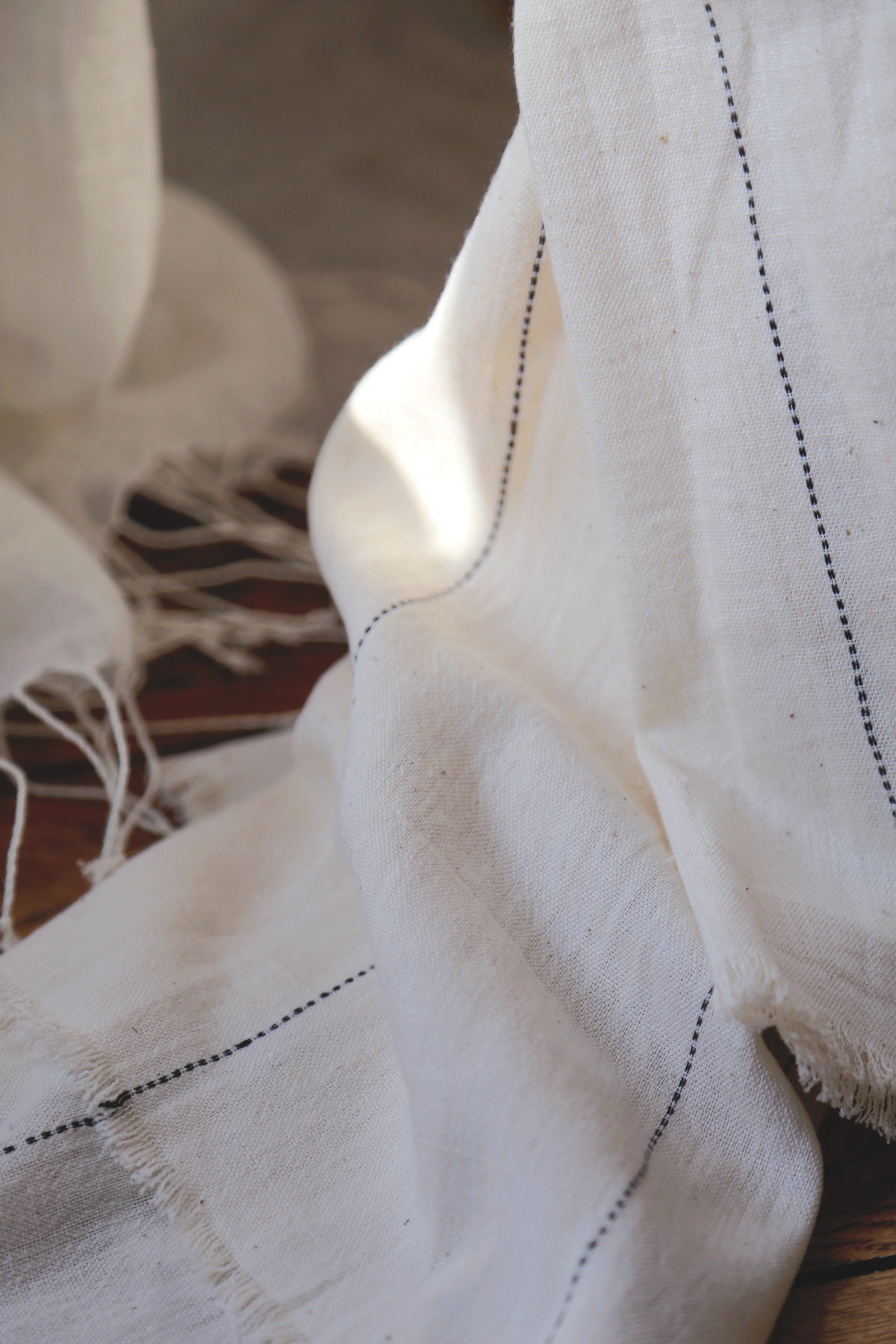 Détail des pointillés noirs sur le rideau Lina en khadi de coton biologique 
