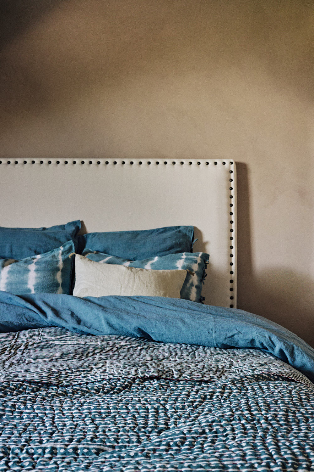 Linge de lit bleu avec une tête de lit blanche