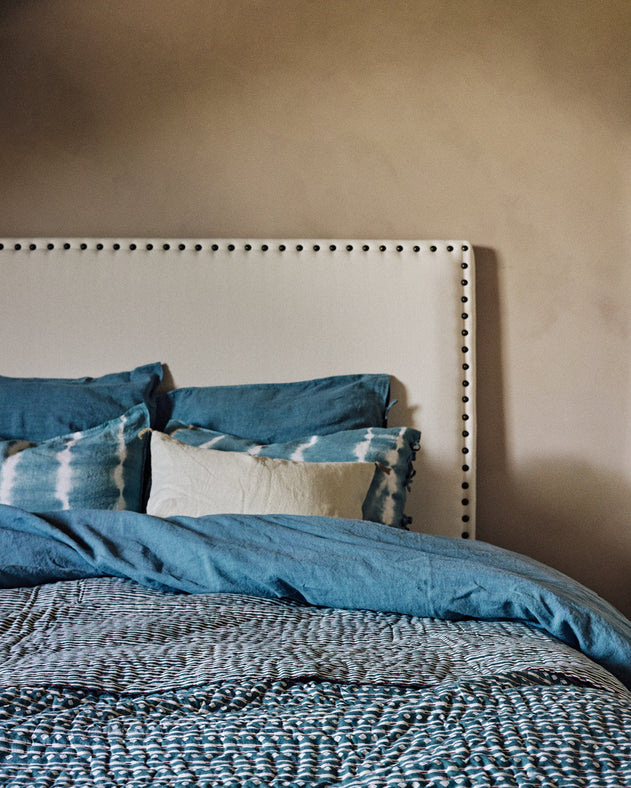 Linge de lit bleu avec une tête de lit blanche