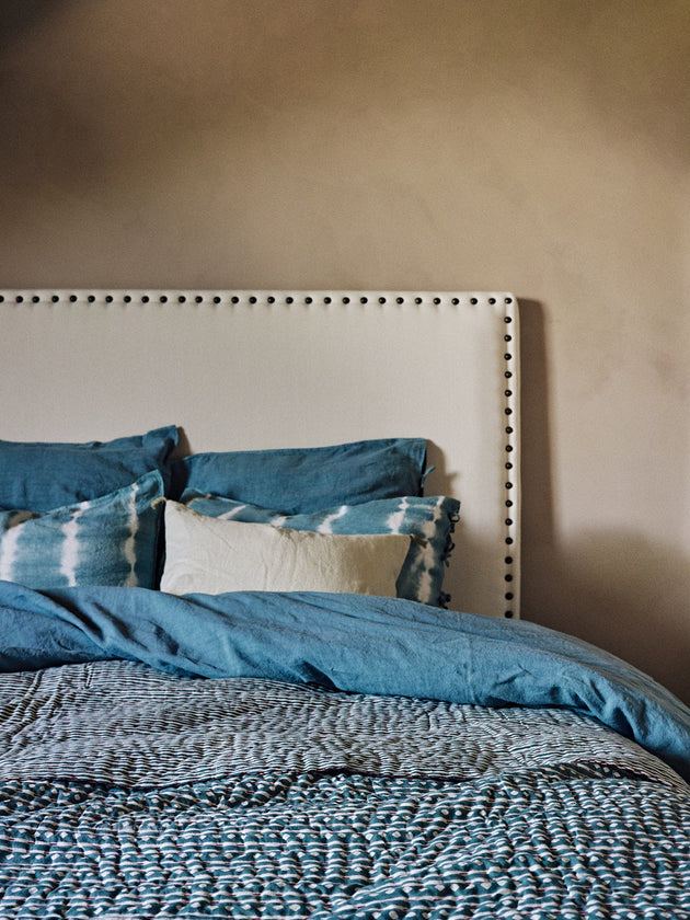 Linge de lit bleu avec une tête de lit blanche