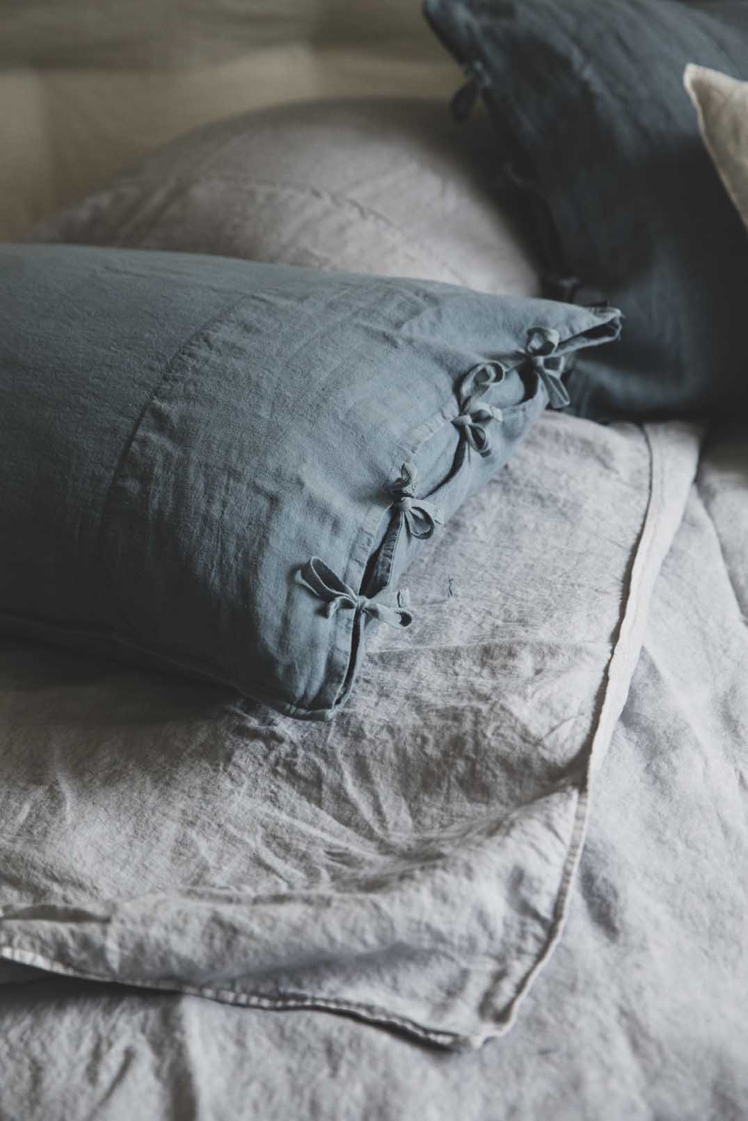Linge de lit : drap en lin lavé gris avec les taies d'oreiller bleues