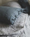 Linge de lit : drap en lin lavé gris avec les taies d'oreiller bleues