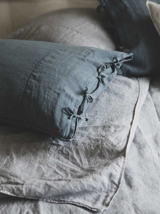 Linge de lit : drap en lin lavé gris avec les taies d'oreiller bleues