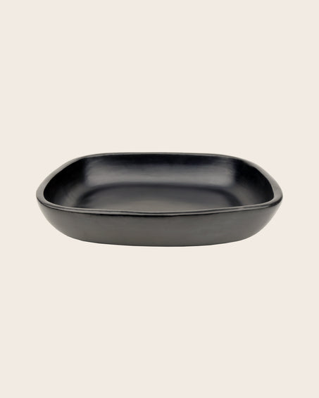 Plat à gratin en terre cuite noir contenant un mélange de 3 argiles