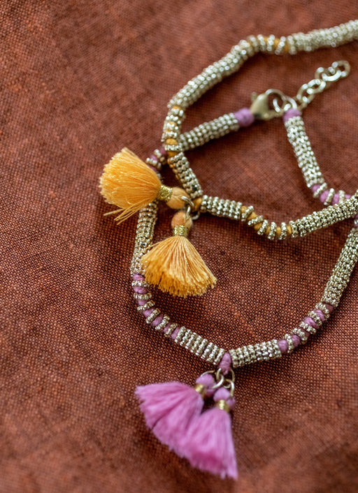 Deux bracelets double pompon en métal et coton rose clair et jaune