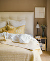 Chambre épuré avec un linge de lit jaune et blanc