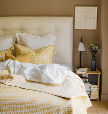 Chambre épuré avec un linge de lit jaune et blanc