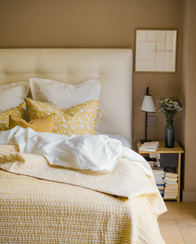Chambre épuré avec un linge de lit jaune et blanc